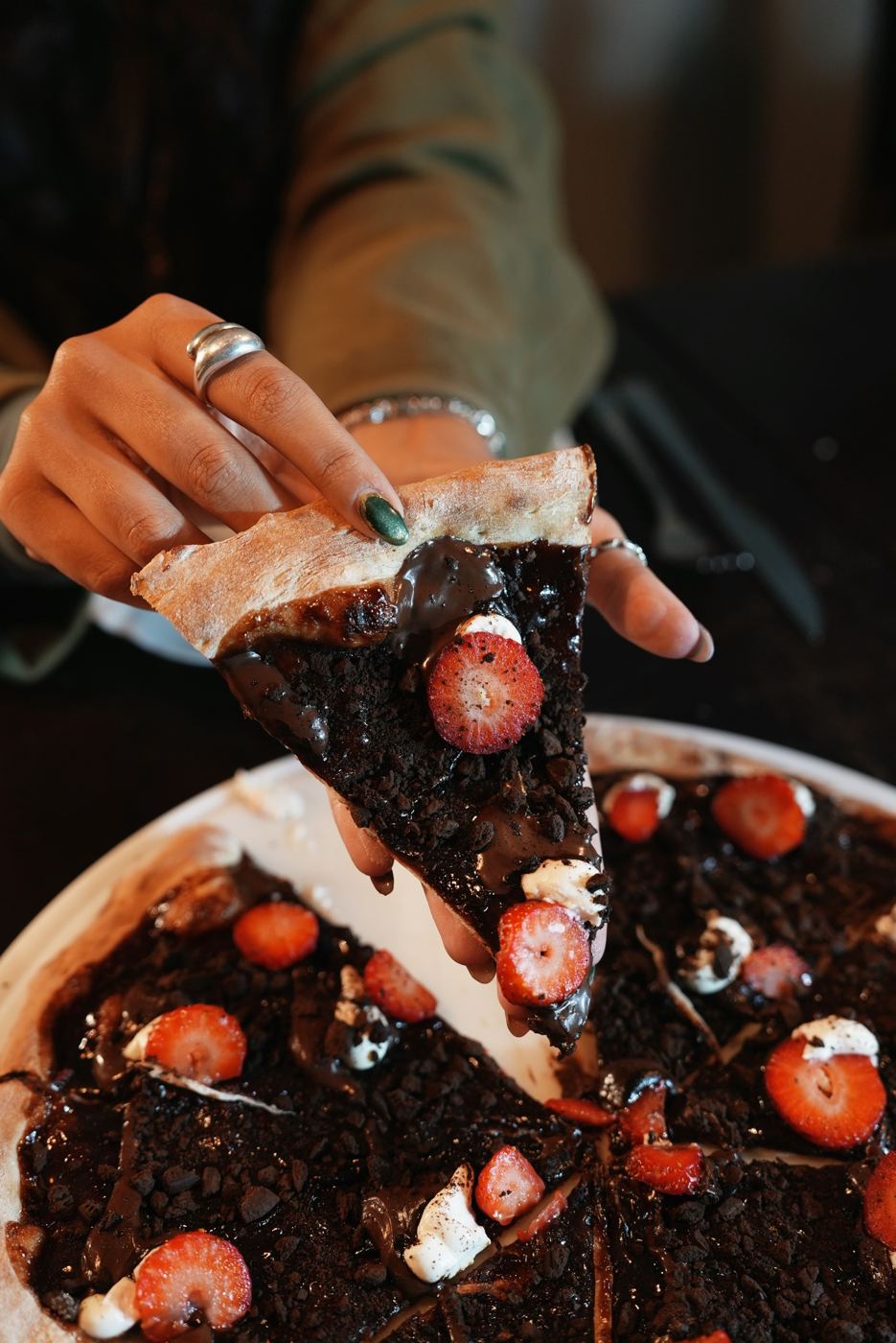 Fatia de pizza doce de chocolate com morango sendo servida